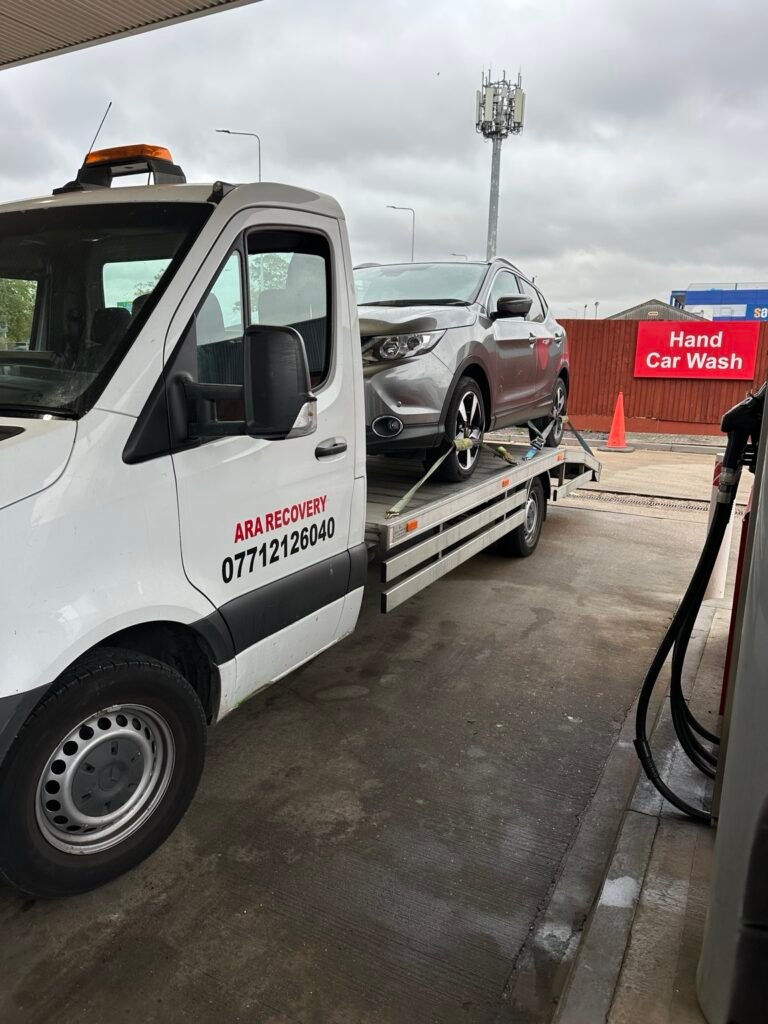 ARA Recovery truck transporting a car at a petrol station