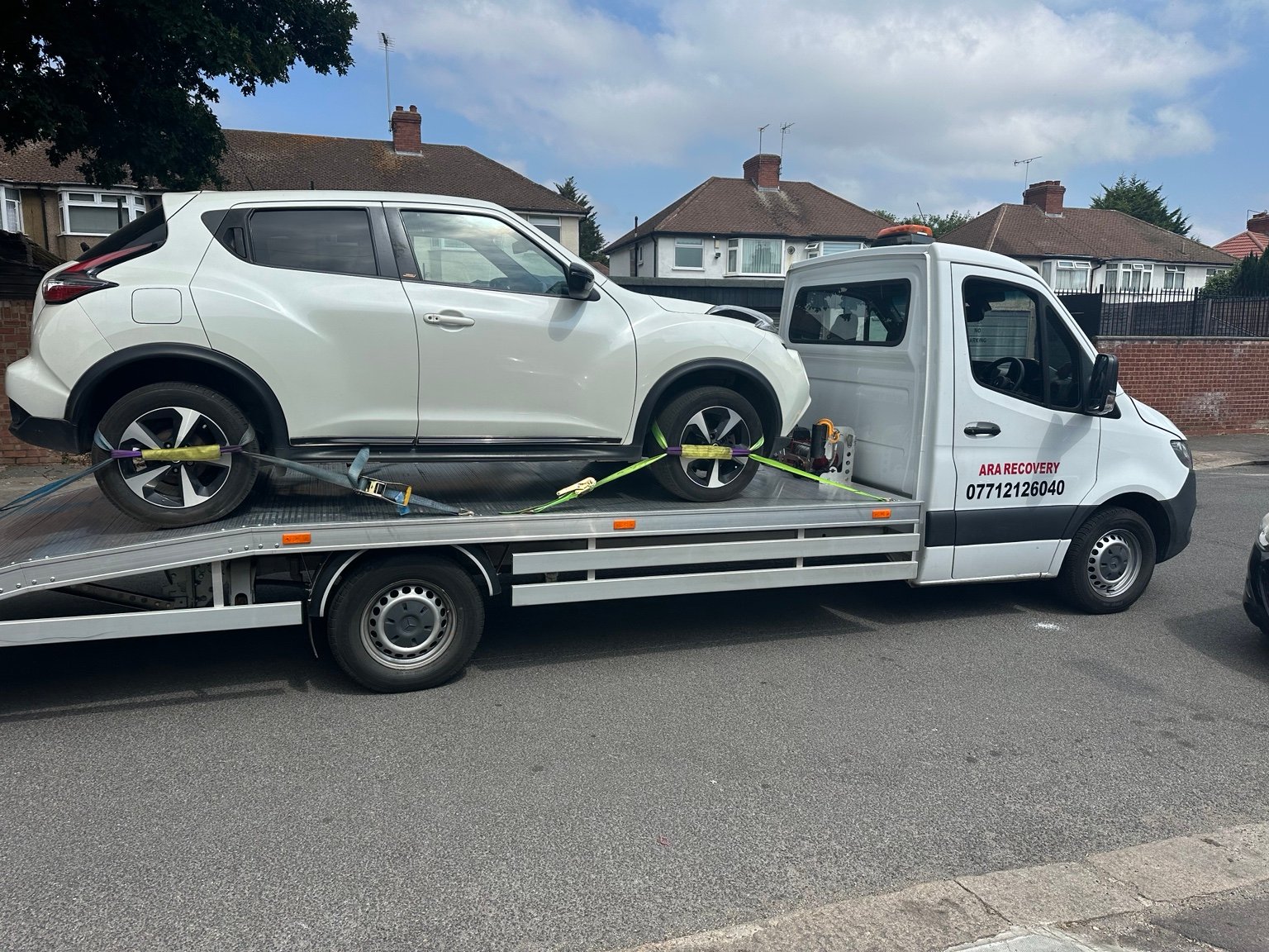 White Nissan SUV secured on the ARA Recovery flatbed truck