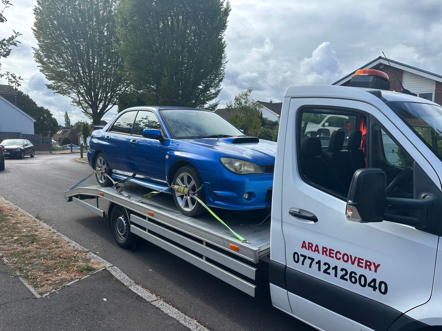 Blue car secured on the ARA Recovery flatbed truck